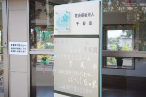 施設の玄関・受付エリア。案内表示とガラスドアが見える。